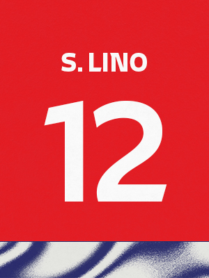Dorsal de color rojo con el nombre 'S. Lino' y el número 12 en blanco, sobre un borde inferior con patrón ondulado azul y blanco.