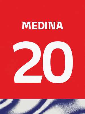 Dorsal de color rojo con el nombre 'Medina' y el número 20 en blanco, sobre un borde inferior con patrón ondulado azul y blanco.