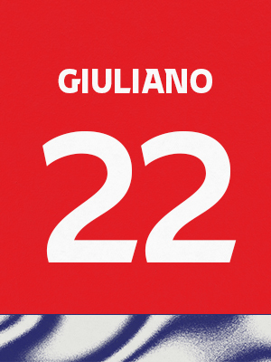 Dorsal de color rojo con el nombre 'Giuliano' y el número 22 en blanco, sobre un borde inferior con patrón ondulado azul y blanco.