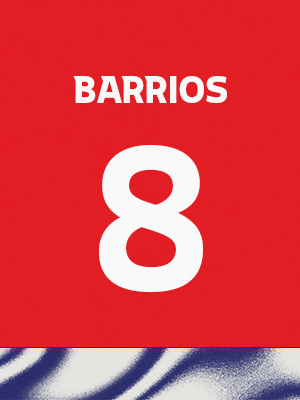 Dorsal de color rojo con el nombre 'Barrios' y el número 8 en blanco, sobre un borde inferior con patrón ondulado azul y blanco.