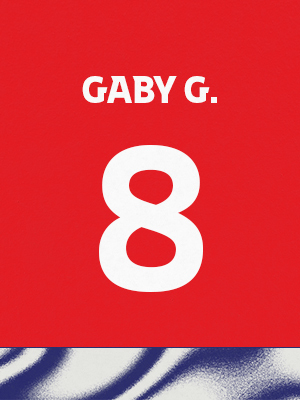 Dorsal de color rojo con el nombre 'Gabyg' y el número 8 en blanco, sobre un borde inferior con patrón ondulado azul y blanco.